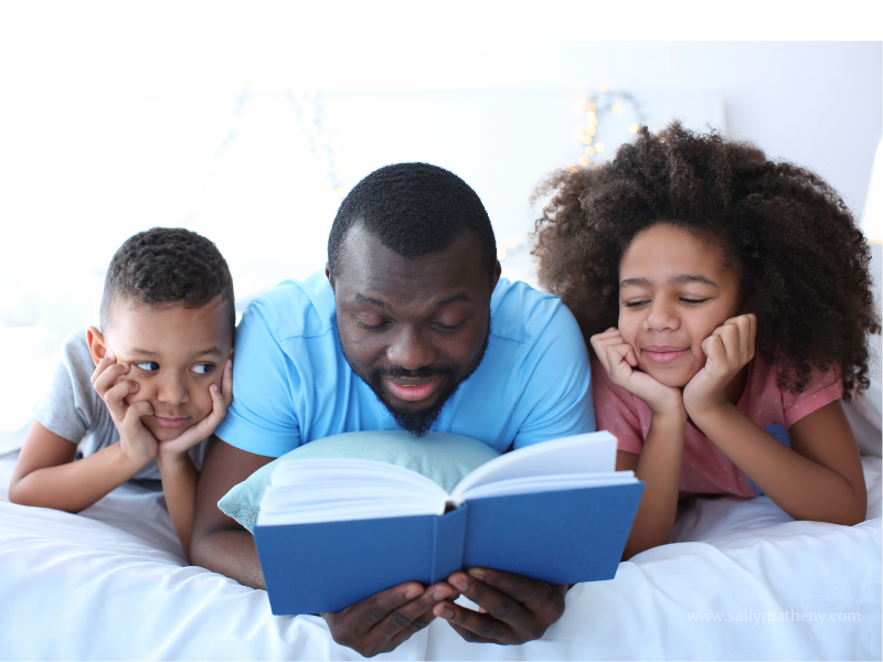 Dad reading book to two children.