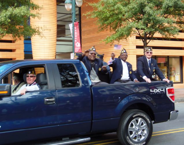 Veterans waving from the back of a truck