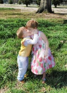 little boy kissing older sister