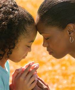 Mom praying with young daughter