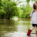 Little girl in raiboots standing in floodwaters