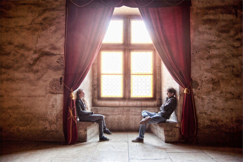 Couple talking in front of large window