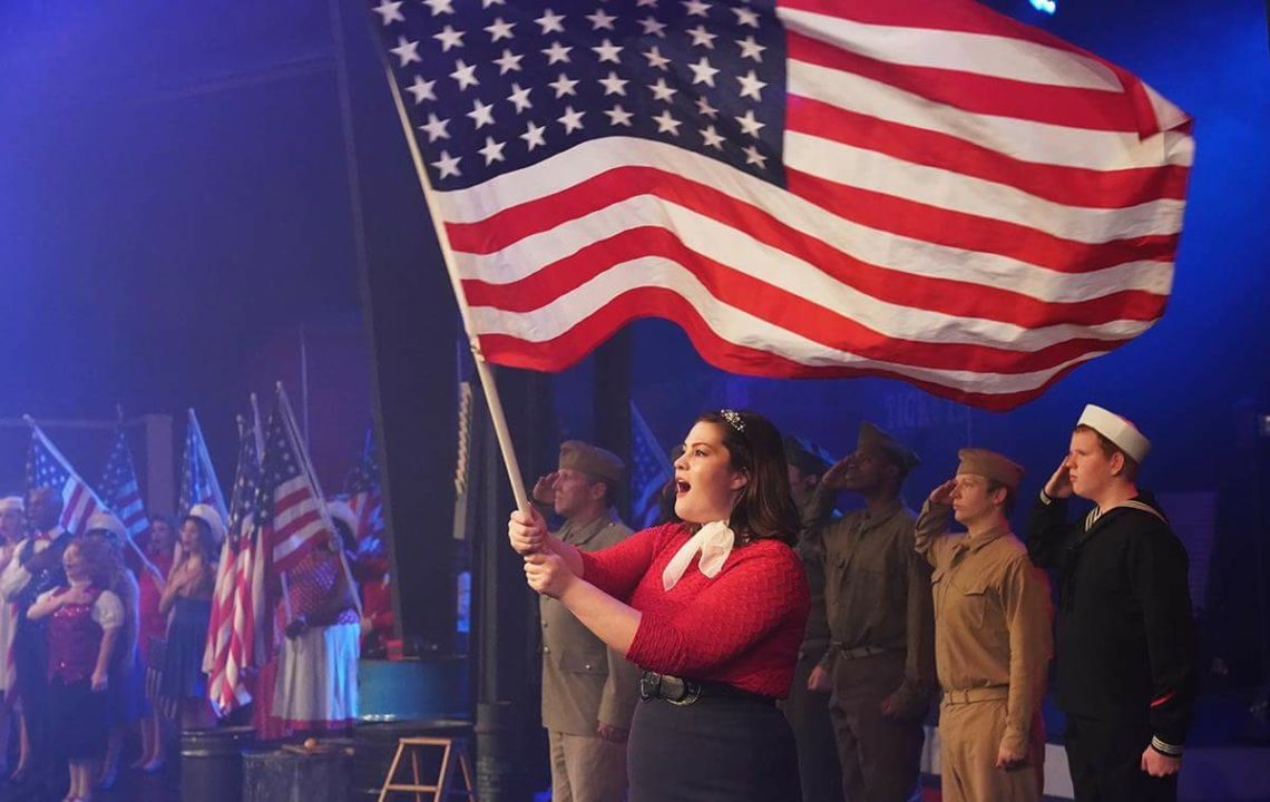 Woman singing and holding American flag