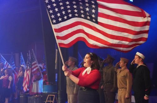 Woman singing and holding American flag