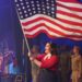 Woman singing and holding American flag