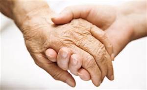 A young hand holding an elderly person's hand.