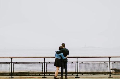 couple on bridge facing fog