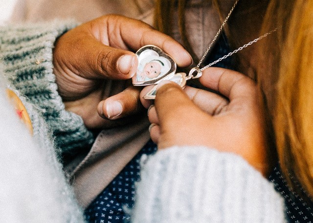 Jennifer Hamrick's daughter looks at Jennifer's locket holding photos of her and her biological mom.