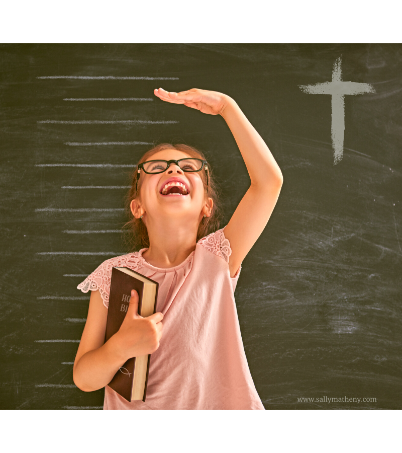 Girl in front of growth chart holding a Bible.