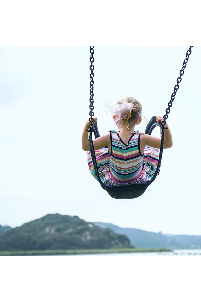 Girl swinging over water