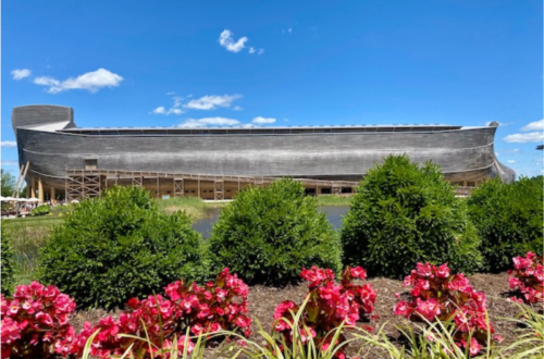 Sally Matheny's photo of the Ark Encounter. Shows huge wooden structure with hot pink flowers and green shrubs in the forefront. 2021.