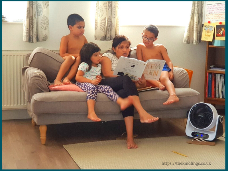 Photo of new homeschool mom, Teresa Marles, reading to her three children in their home in the United Kingdom.