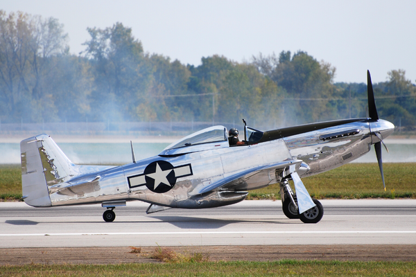 Shows a WWII P-51 Mustang plane about to take off from a runway. (Canva photo). Text: My writing is revving up for 2023!